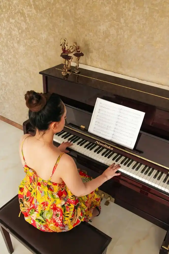 Person playing a grand piano with sheet music